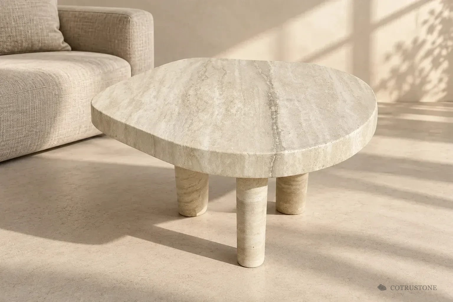 Design visualization of a pale round stone table with three cylindrical supports in a softly lit living room
